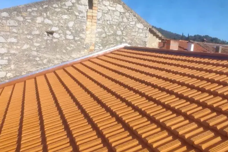 Pose d'une couverture en tuiles canal par un couvreur dans les Alpes-Maritimes